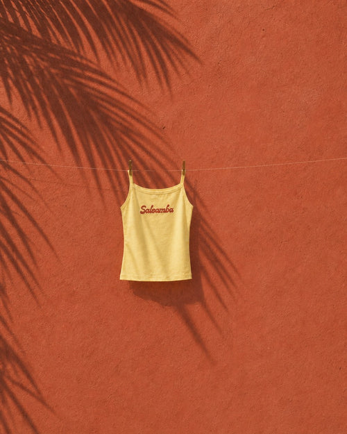 Wide view of the baby yellow Salsamba tank on a clothesline